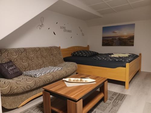 ein Wohnzimmer mit einem Sofa und einem Bett in der Unterkunft FeWo s Runde Wiese WR in Greifswald