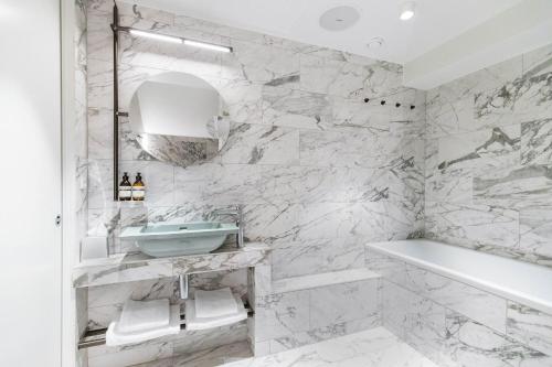 a white bathroom with a sink and a tub at Boutique Hotel Herman K in Copenhagen
