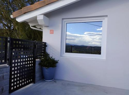 una ventana en el lateral de una casa blanca con una planta en Los Sauces de la Fuente, en Santillana del Mar