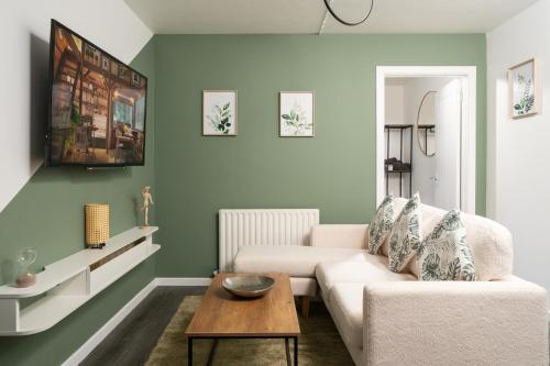 ein Wohnzimmer mit einem Sofa und einem Tisch in der Unterkunft City Vibe Haven - Modern 2 Bed Apartment with High Speed WI-FI in Belfast