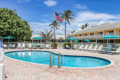uma piscina em frente a um hotel com bandeira americana em Berkshire on the Ocean (timeshare resort) em Delray Beach