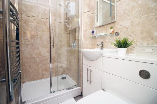 a bathroom with a shower and a sink and a toilet at Perfectly Located City Centre Apartment, Free Parking, Cable TV and WI-FI in Cardiff