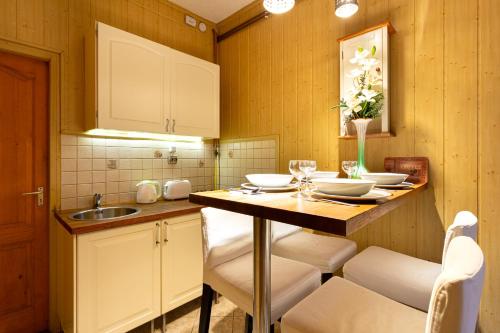 a kitchen with a table with chairs and a sink at Rivercity South Buda Hills in Budapest