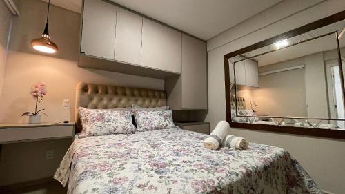 um quarto com uma cama grande e um espelho em Lindo e confortável apartamento no Centro de Foz em Foz do Iguaçu