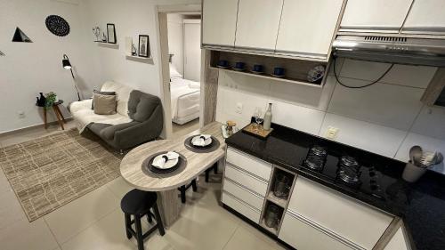 uma cozinha e sala de estar com uma mesa na cozinha em Lindo e confortável apartamento no Centro de Foz em Foz do Iguaçu