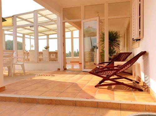 a porch with a rocking chair on a patio at FreeSurfCamp & Hostel in Peniche