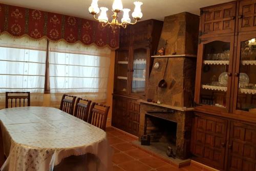 a dining room with a table and a fireplace at Chalet en Miño con vistas al mar in Miño