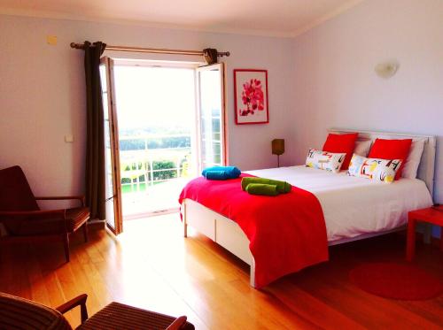 una camera da letto con un grande letto con cuscini rossi e blu di FreeSurfCamp & Hostel a Peniche