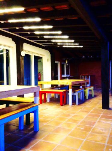 a group of tables and benches in a room at FreeSurfCamp & Hostel in Peniche