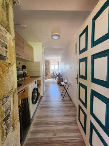 a door to a kitchen with a washer and dryer at Studio face à la Marina, vue mer in Le Marin