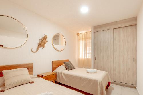 Giường trong phòng chung tại Acogedor apartamento con alberca