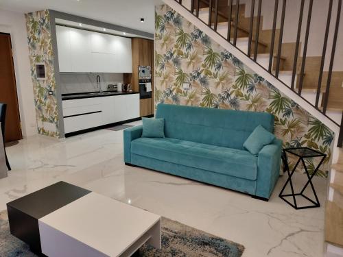 sala de estar con sofá azul y cocina en I MORI Alloggio turistico, en Civitavecchia