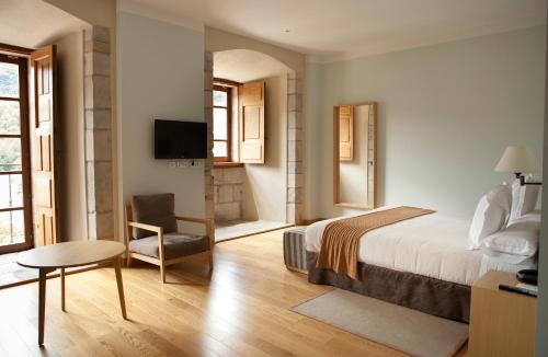 a hotel room with a bed and a chair at Parador de Corias in Cangas del Narcea