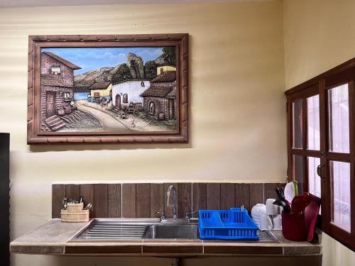 圖盧姆的住宿－Tumben Kuxtal Tulum，厨房配有水槽,墙上挂有绘画作品