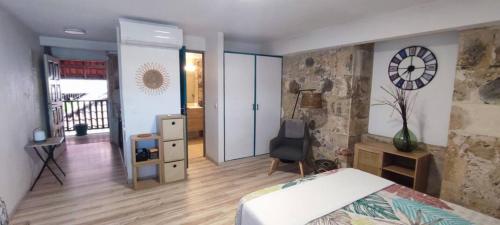 een slaapkamer met een bed en een klok aan de muur bij Studio face à la Marina, vue mer in Le Marin