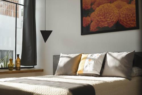 a bedroom with a bed with pillows and a painting on the wall at CASA LUMBA in Guadalajara