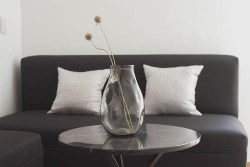 a vase with a flower on a table on a couch at CASA LUMBA in Guadalajara