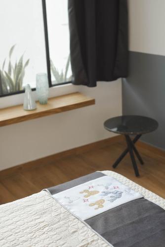 a bedroom with a bed and a stool and a window at CASA LUMBA in Guadalajara