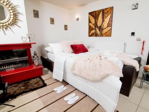 a bedroom with a white bed and a fireplace at Comfy and Cosy Studio Kalamata in Kalamata
