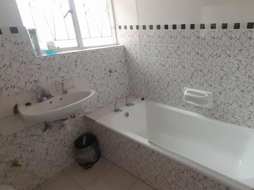 a bathroom with a sink and a bath tub and a sink at Step-by-Step Self-Catering and B&B in Bellville