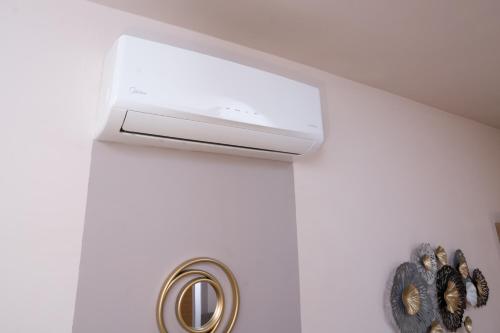 a bathroom sink with a air conditioner on the wall at Comfy and Cosy Studio Kalamata in Kalamata