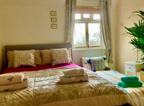 Un dormitorio con una cama grande con almohadas. en Number36, hills garden access, unique retreat en Great Malvern