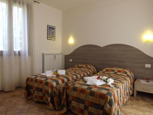 a hotel room with two beds with flowers on them at B&B Il Pizzagiallo in Massa Martana