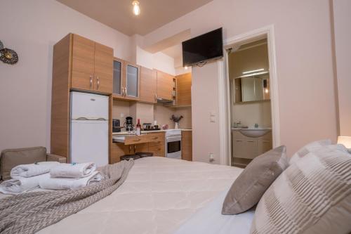 a bedroom with a large white bed and a kitchen at Comfy and Cosy Studio Kalamata B in Kalamata
