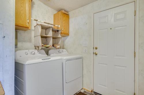 a small laundry room with a washer and dryer at Spacious South Carolina Abode with Hot Tub and Grill! in Columbia
