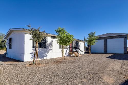two trees in front of a white house at Updated Topock Home with Deck and Fire Pit! in Topock