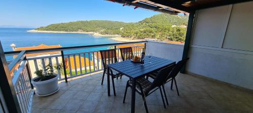 a table and chairs on a balcony with a view of the ocean at Apartment Moli Onte Holiday in Milna