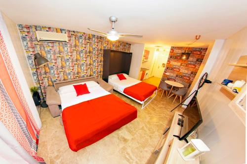トレモリノスにあるZenplaya bajo 5 playa bajondilloのベッド2台とソファが備わるホテルルームです。
