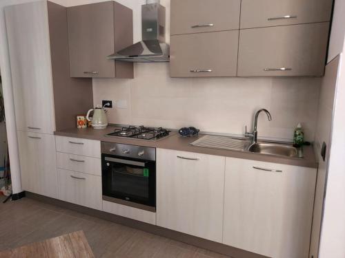 a kitchen with white cabinets and a sink and a stove at Casa dei Marinai a Pegli (Citra: 010025-LT-4074) in Genova