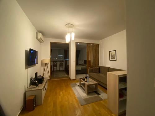 - un salon avec un canapé et une table dans l'établissement Delta Apartman, à Podgorica
