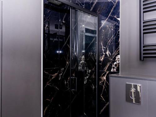 W łazience znajduje się prysznic ze szklanymi drzwiami. w obiekcie Brama do lasu - Domek Energia w mieście Borków
