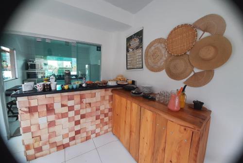 uma cozinha com um balcão com chapéus na parede em Pousada Canto Dos Passaros em Pirenópolis