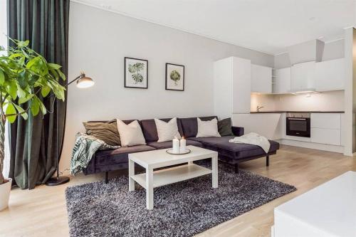 een woonkamer met een bank en een tafel bij NEW modern apartment at Solsiden in Trondheim