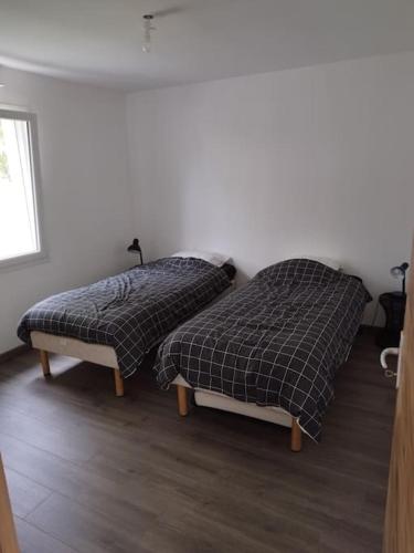 dos camas sentadas una al lado de la otra en una habitación en Gîte, en Les Moitiers-dʼAllonne