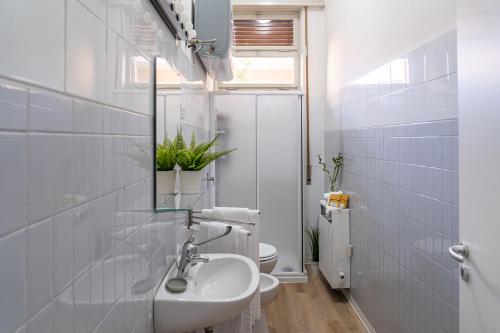 une salle de bain blanche avec un lavabo et des toilettes dans l'établissement Casa Golgi - Pavia City - by Host4U, à Pavia