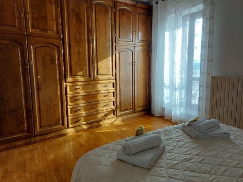 a bedroom with wooden cabinets and a bed with towels on it at Casa Rosita vista lago in Bolsena