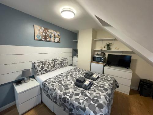 a bedroom with a bed with a black and white comforter at Kensal Lodge 2 Guest House in London