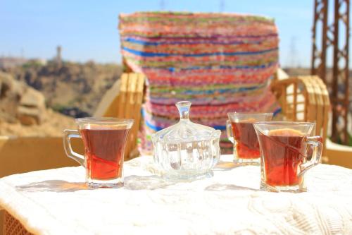 een tafel met twee glazen thee en een glazen kruik bij KoshTaka-كوشتاكا in Naj‘ al Maḩaţţah