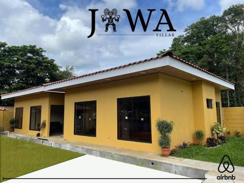 een klein geel huis met het jwx bord erboven bij Villas Jawa in Puerto Limón