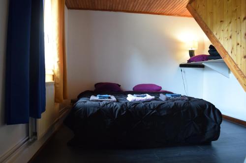Un dormitorio con una cama con ropa. en Studio à la campagne proche du lac 