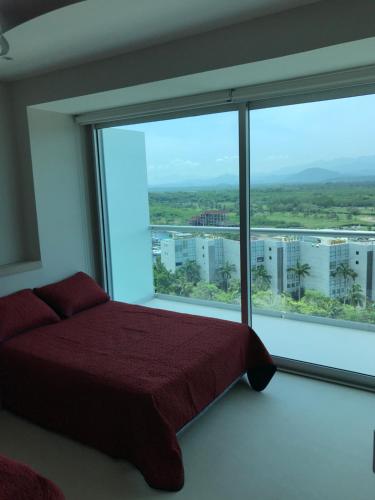 a bedroom with a bed and a large window at Peninsula 12 D in Ixtapa