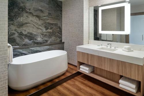 y baño con bañera, lavabo y espejo. en SpringHill Suites by Marriott Franklin Mint, en Franklin
