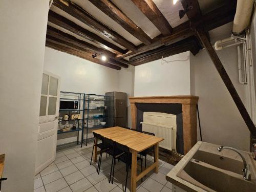 une cuisine avec une table en bois et une cheminée dans l'établissement Cosy T3-Hyper Centre-Netflix, à Angers