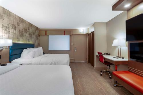 a hotel room with two beds and a desk at Best Western PLUS City Centre Inn in Edmonton