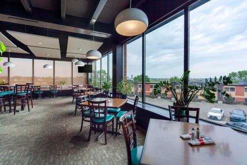 ein Restaurant mit Tischen und Stühlen und großen Fenstern in der Unterkunft Best Western PLUS City Centre Inn in Edmonton