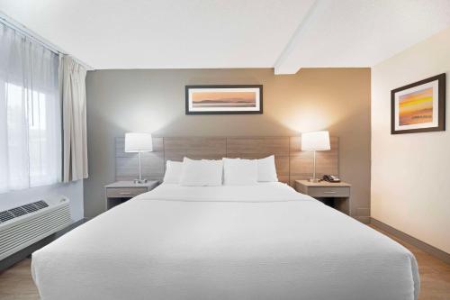ein Schlafzimmer mit einem großen weißen Bett und zwei Lampen in der Unterkunft Quality Inn Idaho Falls in Idaho Falls